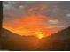 A fiery desert sunset illuminates the surrounding mountains at 11935 E Casitas Del Rio Dr, Scottsdale, AZ 85255