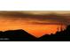 The sky glows with a warm orange hue during sunset in the desert at 11935 E Casitas Del Rio Dr, Scottsdale, AZ 85255