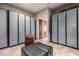 Large walk-in closet with frosted glass door cabinets, ottoman, and basket for organized storage at 11935 E Casitas Del Rio Dr, Scottsdale, AZ 85255