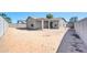 Backyard with block wall, patio, rear exterior of a neutral colored stucco home, and desert landscape at 1316 E Spencer St, Casa Grande, AZ 85122
