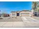 Charming single story home showcasing a desert landscape, a two car garage and a blue front door at 1316 E Spencer St, Casa Grande, AZ 85122