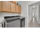 Laundry room featuring side by side appliances, overhead cabinets and a view into the hallway at 1316 E Spencer St, Casa Grande, AZ 85122