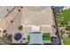 Aerial view of the house showcasing a backyard with a trampoline, playground, grill, and covered patio at 13637 W Port Royale Ln, Surprise, AZ 85379