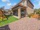 The backyard features a covered patio, an outdoor kitchen, a play set, and gravel groundcover at 13637 W Port Royale Ln, Surprise, AZ 85379