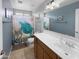 Cozy bathroom featuring a turtle themed shower curtain, white vanity, and light blue walls at 13637 W Port Royale Ln, Surprise, AZ 85379