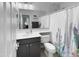 Clean and bright bathroom with white fixtures, a vanity and shower with cactus themed curtain at 13637 W Port Royale Ln, Surprise, AZ 85379