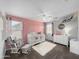 Charming Bedroom with a rocking chair, white crib, plush rug, and pink accent wall at 13637 W Port Royale Ln, Surprise, AZ 85379
