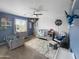Lovely bedroom featuring a crib, toddler bed, fan, window, and a fun hammock for stuffed animals at 13637 W Port Royale Ln, Surprise, AZ 85379