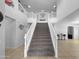 Bright entryway featuring a grand staircase with white railings and tiled floors at 13637 W Port Royale Ln, Surprise, AZ 85379