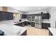 Modern kitchen with stainless steel appliances, dark cabinetry, and a quartz countertop at 13637 W Port Royale Ln, Surprise, AZ 85379