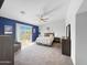 Bright main bedroom featuring a ceiling fan, and a sliding glass door to the backyard at 13637 W Port Royale Ln, Surprise, AZ 85379