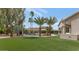 Expansive backyard with lush artificial grass, desert landscaping, outdoor kitchen, and sparkling pool at 1405 W Caribbean Ln, Phoenix, AZ 85023
