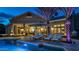 Backyard pool area with lounge chairs, mature landscaping, and hot tub, beautifully lit at twilight at 1405 W Caribbean Ln, Phoenix, AZ 85023