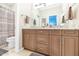 Bathroom includes double vanity with granite counters, decorative mirror, and a shower/tub combo at 1405 W Caribbean Ln, Phoenix, AZ 85023