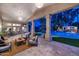 View of a covered patio, backyard, and pool with an outdoor kitchen at dusk at 1405 W Caribbean Ln, Phoenix, AZ 85023