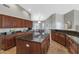 Spacious kitchen with dark wood cabinets, a large island, and tile flooring at 1405 W Caribbean Ln, Phoenix, AZ 85023