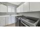 Functional laundry room with white cabinets, sink, and stainless steel washer and dryer at 1405 W Caribbean Ln, Phoenix, AZ 85023