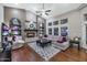 Cozy living room with a stone fireplace, ceiling fan, and views of the backyard at 1405 W Caribbean Ln, Phoenix, AZ 85023