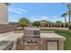 Built-in outdoor kitchen features a stainless steel grill, mini refrigerator, and counter space at 1405 W Caribbean Ln, Phoenix, AZ 85023