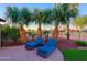 Backyard featuring palm trees, lounge chairs, manicured rock and grass landscaping at 15954 W Sheila Ln, Goodyear, AZ 85395