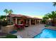 Inviting backyard featuring a pool, covered patio, outdoor seating, and lush palm trees creating a relaxing oasis at 15954 W Sheila Ln, Goodyear, AZ 85395
