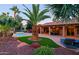 Lush backyard oasis featuring a pool, tropical landscaping and outdoor seating area at 15954 W Sheila Ln, Goodyear, AZ 85395
