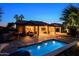 Stunning backyard showcasing a shimmering pool, covered patio, and lush landscaping, perfect for entertaining at 15954 W Sheila Ln, Goodyear, AZ 85395