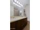 Bathroom showcasing dual sinks with granite countertops, tub/shower combo, tile flooring, and wood cabinets at 15954 W Sheila Ln, Goodyear, AZ 85395