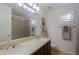 Bathroom showcasing dual sinks with granite countertops, tub/shower combo, tile flooring, and wood cabinets at 15954 W Sheila Ln, Goodyear, AZ 85395