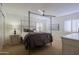 Bedroom with four-poster bed, ceiling fan, plush carpet, plantation shutters, and neutral paint at 15954 W Sheila Ln, Goodyear, AZ 85395