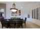 Formal dining room with a dark wood table, decorative centerpiece, and elegant lighting underneath art on the wall at 15954 W Sheila Ln, Goodyear, AZ 85395