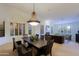 Traditional dining room with wood table, chairs, and a decorative chandelier, bathed in natural light from shuttered windows at 15954 W Sheila Ln, Goodyear, AZ 85395