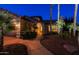 Beautiful home at night highlighting its three-car garage, arched entrance, and mature landscaping with palm trees at 15954 W Sheila Ln, Goodyear, AZ 85395