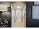 Bright hallway with mirrored walls leads to the main bathroom with crystal chandelier at 15954 W Sheila Ln, Goodyear, AZ 85395