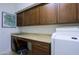 Functional laundry area with cabinets above counter, sink, desk space and machines at 15954 W Sheila Ln, Goodyear, AZ 85395