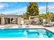 Beautiful backyard with a pool, spa, outdoor kitchen, and comfortable lounge seating under festive string lights at 1609 W State Ave, Phoenix, AZ 85021