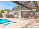 Serene backyard with a pool, spa, covered patio, outdoor kitchen, and lush landscaping at 1609 W State Ave, Phoenix, AZ 85021
