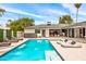 Lush backyard featuring a pool, spa, lounge chairs, and covered patios, perfect for outdoor entertaining at 1609 W State Ave, Phoenix, AZ 85021