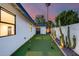 Private backyard with putting green, desert landscaping, and stylish exterior lighting for nighttime enjoyment at 1609 W State Ave, Phoenix, AZ 85021
