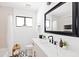 Bright bathroom with black framed mirror, marble sink, and subway tile in the shower at 1609 W State Ave, Phoenix, AZ 85021