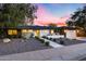 Charming single-story home with modern updates, featuring a bright yellow door and stylish desert landscaping at 1609 W State Ave, Phoenix, AZ 85021