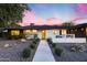 Inviting single-story home with a bright yellow front door and a cozy patio with a modern fire feature at 1609 W State Ave, Phoenix, AZ 85021