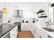 Modern kitchen with white cabinets, black hardware, and a stainless steel range hood at 1609 W State Ave, Phoenix, AZ 85021