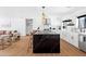 Modern kitchen featuring white cabinets, black marble island, stainless steel appliances and view to the living room at 1609 W State Ave, Phoenix, AZ 85021