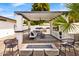 Stunning outdoor kitchen and lounge area featuring a built-in grill, bar, firepit, and stylish seating at 1609 W State Ave, Phoenix, AZ 85021