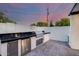 Outdoor kitchen with stainless steel grill, refrigerator, and sleek countertop for grilling and entertaining outdoors at 1609 W State Ave, Phoenix, AZ 85021
