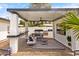 Backyard featuring an outdoor kitchen, covered patio with modern furniture, and a stylish striped rug at 1609 W State Ave, Phoenix, AZ 85021