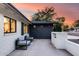 Side patio featuring modern outdoor furniture, a sleek fire pit, and stylish white brick accents at 1609 W State Ave, Phoenix, AZ 85021