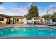 Inviting pool area with an outdoor kitchen, open living spaces, and lounge area illuminated by string lights at 1609 W State Ave, Phoenix, AZ 85021