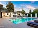 Beautiful pool featuring an outdoor kitchen, cozy lounge area, and seamless connection to the home's interior at 1609 W State Ave, Phoenix, AZ 85021